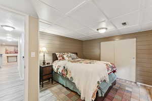 Bedroom featuring wooden walls and a closet