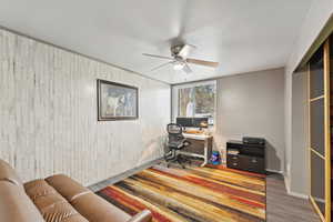 Office space with ceiling fan, wood finished floors, and a textured ceiling
