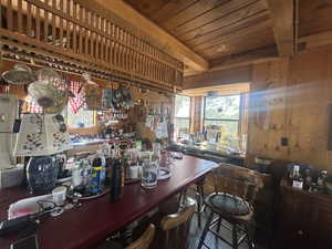 Bar area featuring wood walls, a workshop area, and wooden ceiling