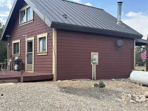 View of home's exterior with a standing seam roof, a deck, and a metal roof