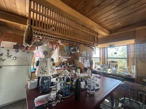 Kitchen with freestanding refrigerator and wooden ceiling