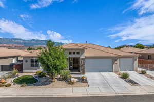 Prairie-style home with a tile roof, stucco siding, driveway, and an attached garage
