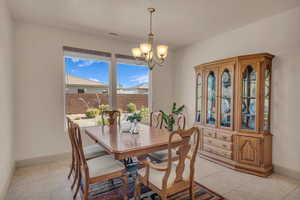 Dining area with a chandelier and light tile patterned floors