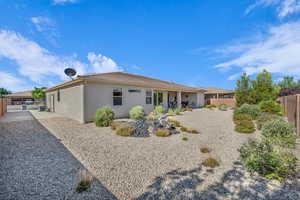 Back of house with stucco siding and a gate