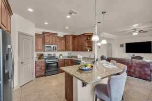 Kitchen featuring open floor plan, a peninsula, open shelves, stainless steel appliances, and light tile patterned flooring