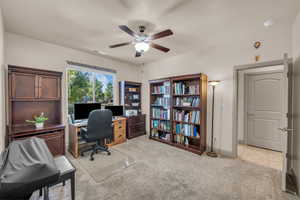 Office with ceiling fan and light carpet