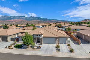 View of front of house featuring a residential view, a mountain view, stucco siding, an attached garage, and concrete driveway