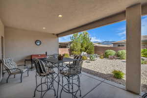 Fenced backyard with a patio area, a mountain view, outdoor dining space, and area for grilling