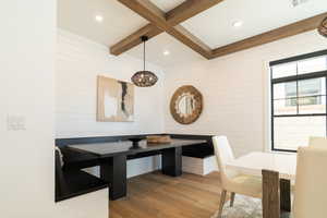 Dining space with beam ceiling, wood finished floors, recessed lighting, and wooden walls