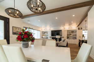 Dining room featuring beam ceiling, recessed lighting, wood finished floors, plenty of natural light, and a chandelier