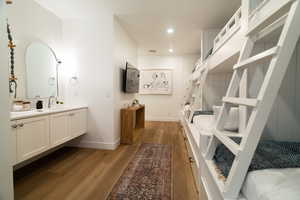 Bathroom with vanity, wood finished floors, and recessed lighting