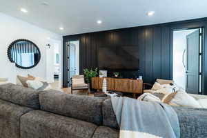 Living area with wooden walls, recessed lighting, and light wood-type flooring