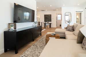 Living area featuring light wood finished floors and recessed lighting