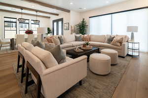 Living area featuring wood finished floors, recessed lighting, beam ceiling, and a chandelier