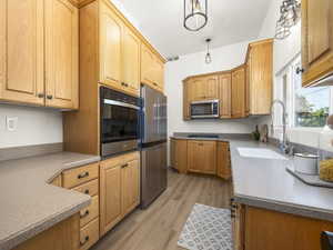 Kitchen with appliances with stainless steel finishes and light wood-style flooring