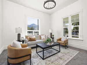 Living area with a chandelier, carpet flooring, and a mountain view