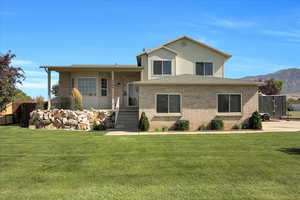 Tri-level home featuring brick siding and a front yard