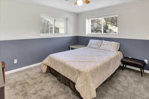 Carpeted bedroom with baseboards and a ceiling fan