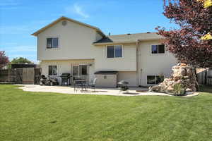 Rear view of house with a patio area and a gate