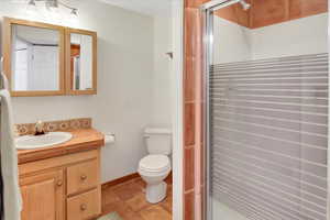 Bathroom with vanity, a shower stall, and tile patterned floors