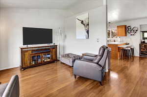 Living area with light wood-type flooring and lofted ceiling