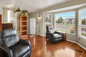 Sitting room featuring healthy amount of natural light and wood finished floors
