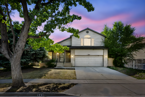 Traditional-style home with driveway, an attached garage, and brick siding