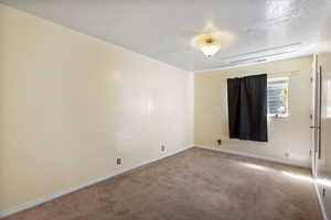Spare room featuring carpet flooring and a textured ceiling