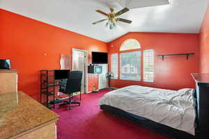 Bedroom with carpet, vaulted ceiling, a textured ceiling, a desk, and ceiling fan