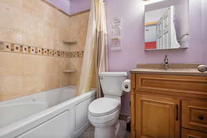 Bathroom featuring vanity and shower / bathtub combination with curtain
