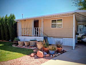 Manufactured / mobile home with an attached carport and a front yard