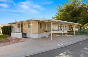 View of front of house featuring concrete driveway and an attached carport