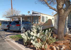 View of front of house with concrete driveway and a carport