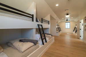 Bedroom featuring light wood-style floors, lofted ceiling, and recessed lighting