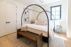 Bedroom with wood finished floors and a closet