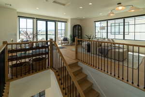 Stairs featuring healthy amount of natural light, wood finished floors, and recessed lighting