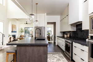 Kitchen with dark countertops, modern cabinets, and stainless steel appliances