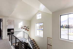 Staircase featuring carpet flooring, lofted ceiling, and a mountain view
