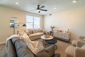 Living area with a ceiling fan, recessed lighting, a textured ceiling, and arched walkways