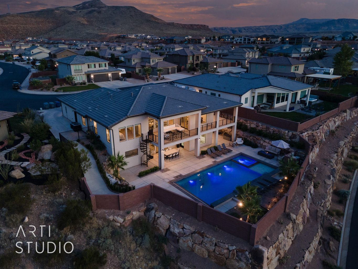 Aerial view at dusk of view of pool area, a mountain view, and a residential view