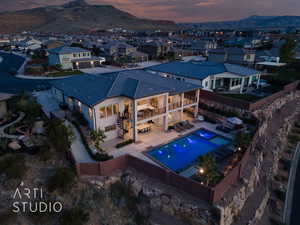Aerial view at dusk of view of pool area, a mountain view, and a residential view