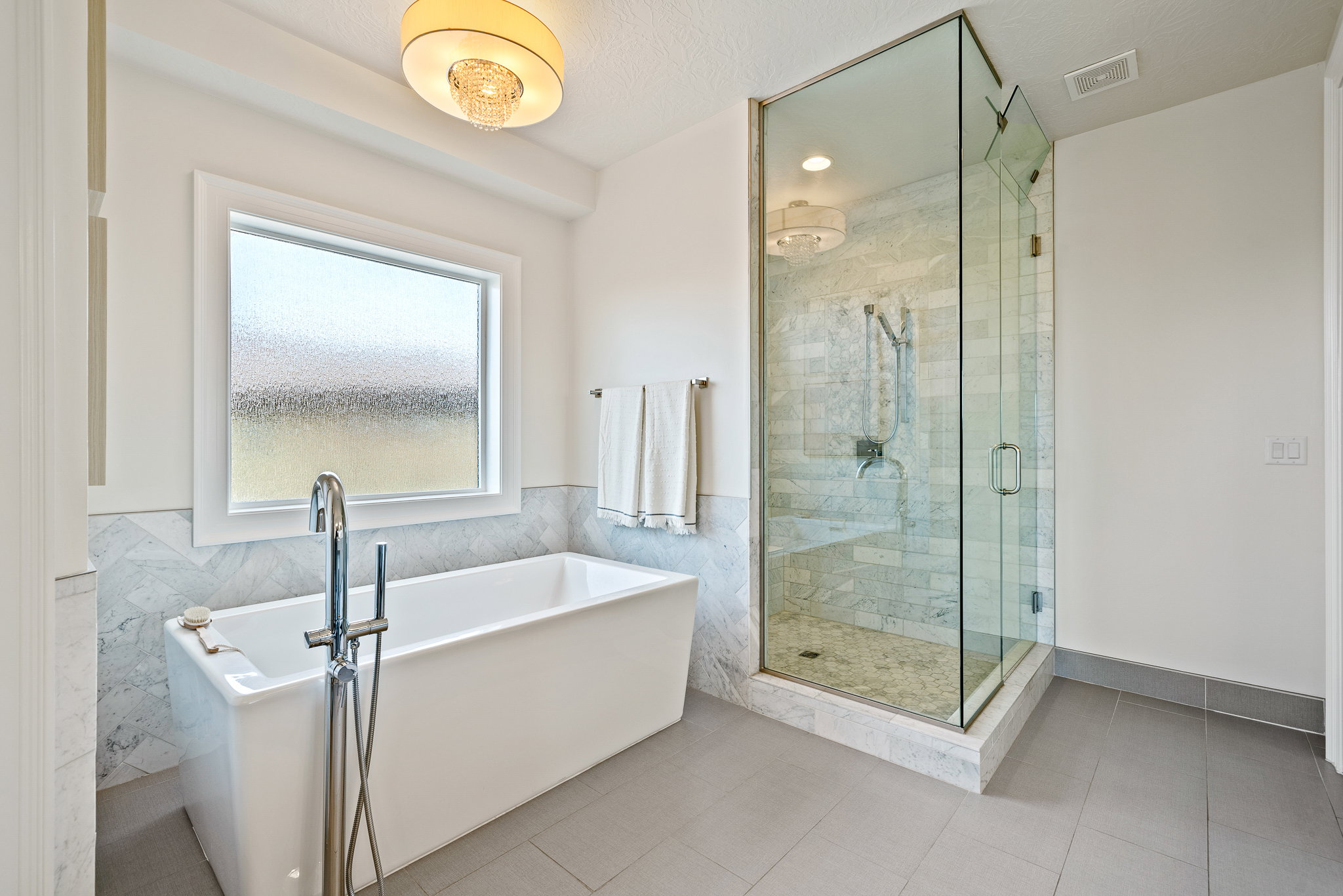 Full bathroom featuring a freestanding bath, a stall shower, tile patterned floors, wainscoting, and tile walls