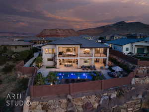 Rear view of property featuring a balcony, a fenced backyard, an outdoor living space, a patio, and a mountain view