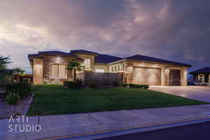 Prairie-style home with stone siding, an attached garage, concrete driveway, and a lawn
