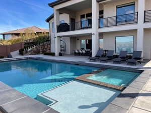 View of swimming pool featuring a patio, a pool with connected hot tub, and outdoor dining area