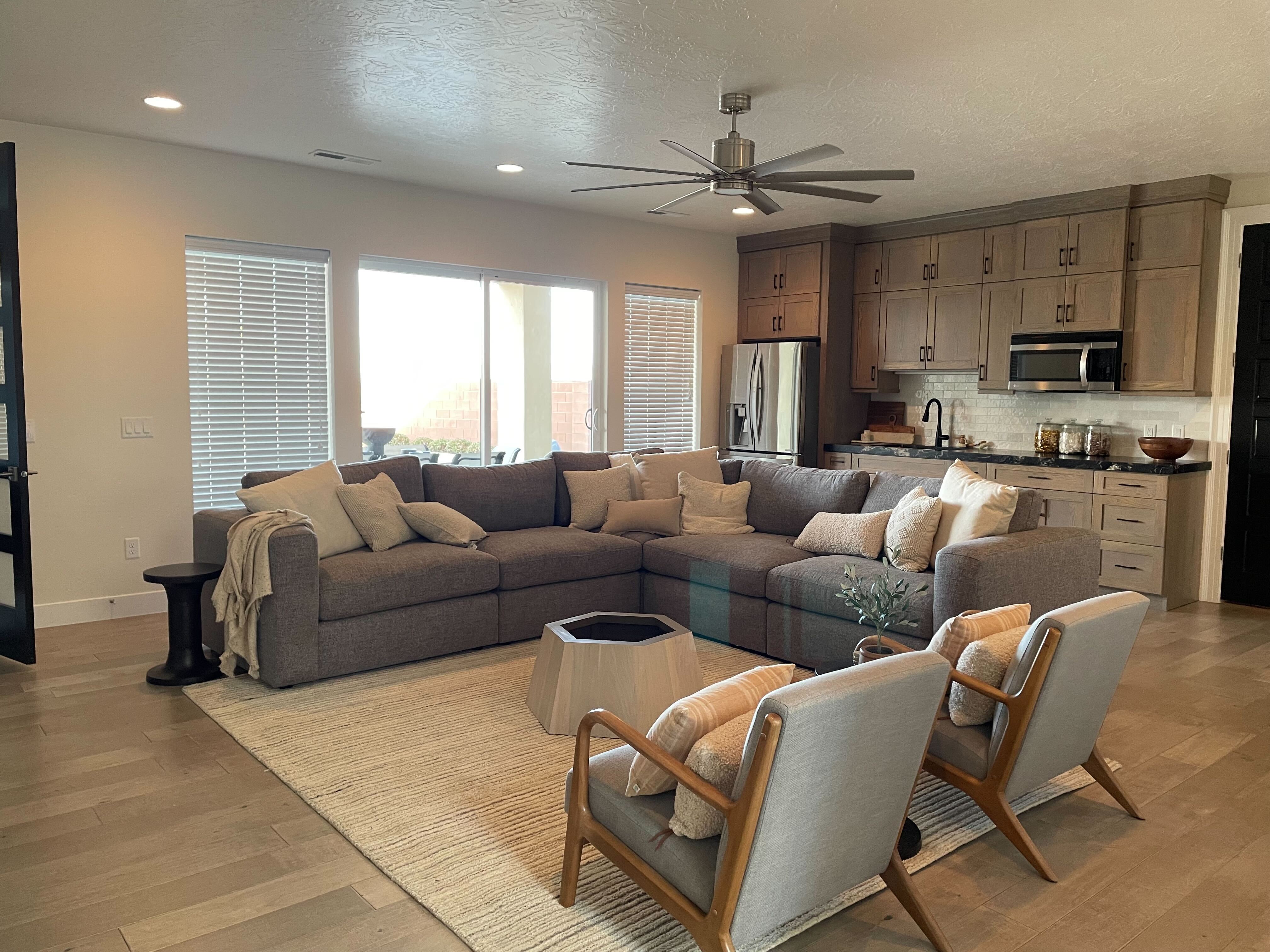 Living room with a textured ceiling, recessed lighting, ceiling fan, and light wood finished floors