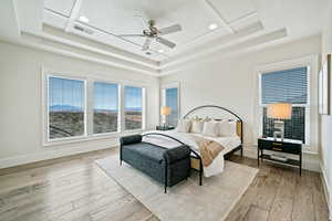 Bedroom featuring a tray ceiling, recessed lighting, hardwood / wood-style floors, and ceiling fan