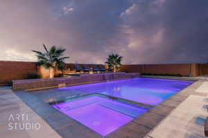 View of pool featuring a pool with connected hot tub and a fenced backyard