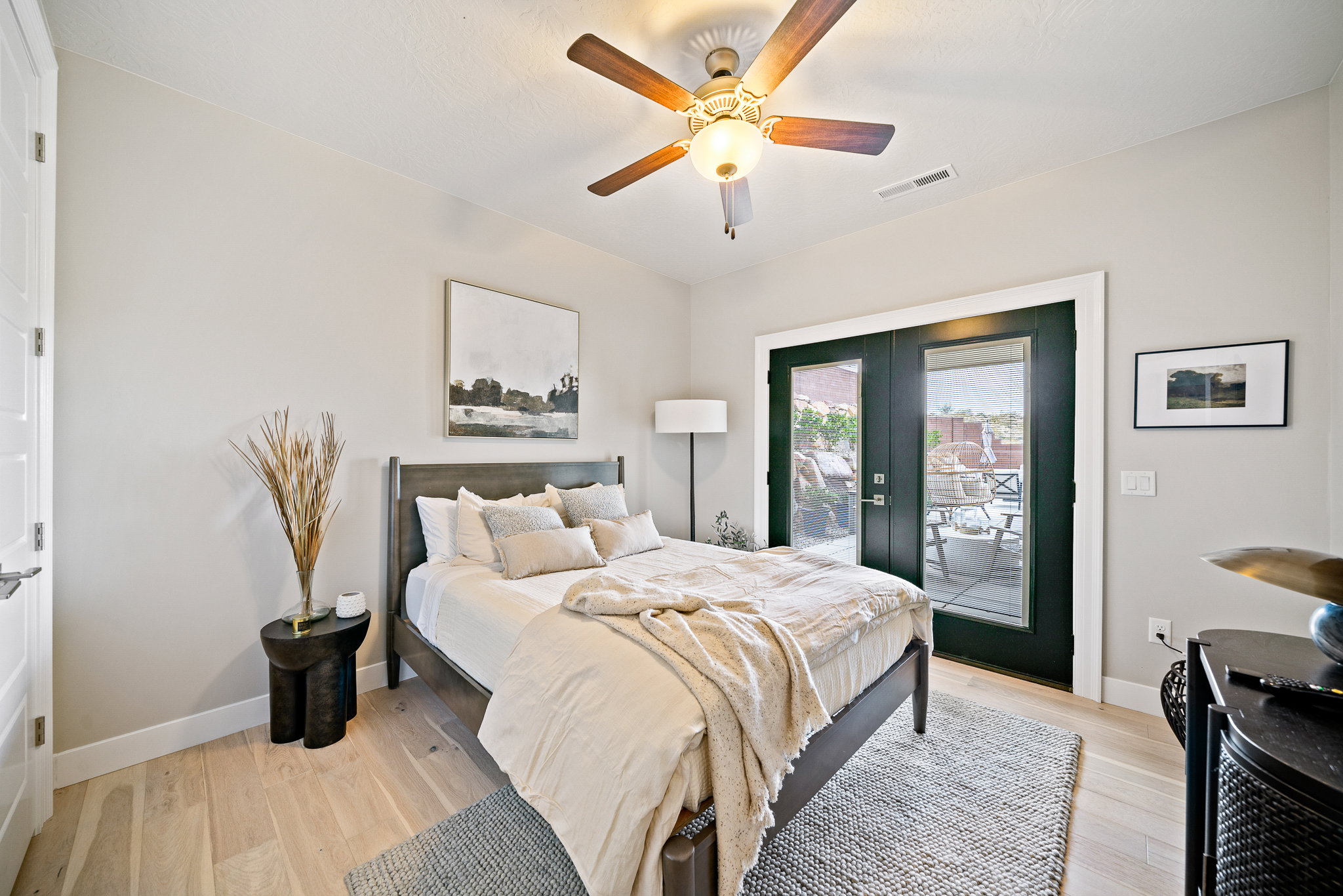 Bedroom with access to outside, french doors, light wood-style floors, and a ceiling fan