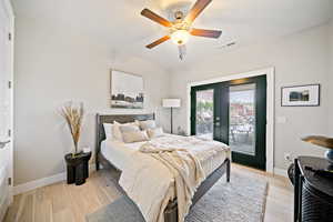 Bedroom with access to outside, french doors, light wood-style floors, and a ceiling fan